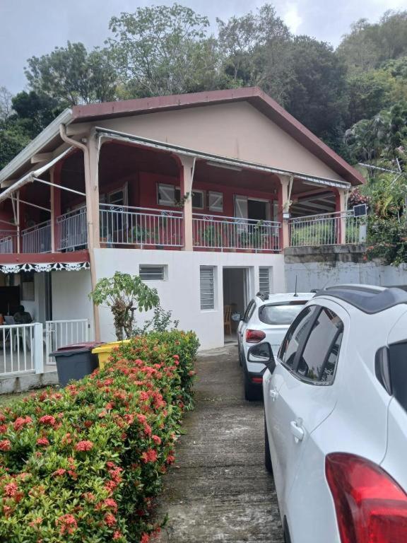 a house with cars parked in front of it at Résidence EmiRose in Rivière-Pilote
