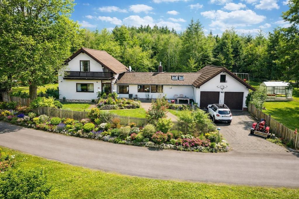 a house with a car parked in the driveway at Nürburgring Eifelhaus in Baar