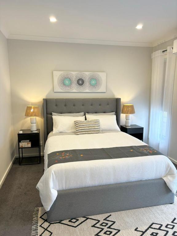 a bedroom with a large bed with two night stands at Cozy room with an Ensuite in Clyde North