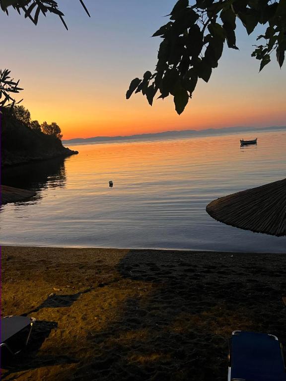 a sunset over the water with two boats in it at Mani Sea View Rooms in Gythio