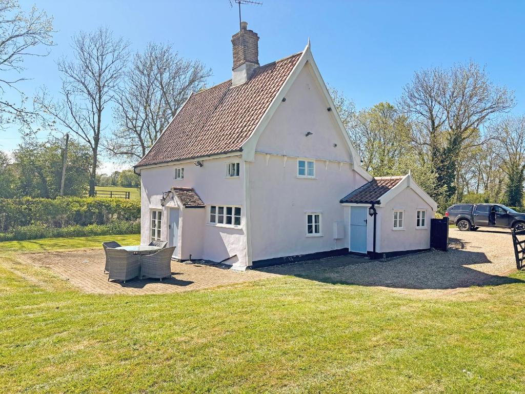 a large white house with a grass yard at Willow Cottage in Framlingham