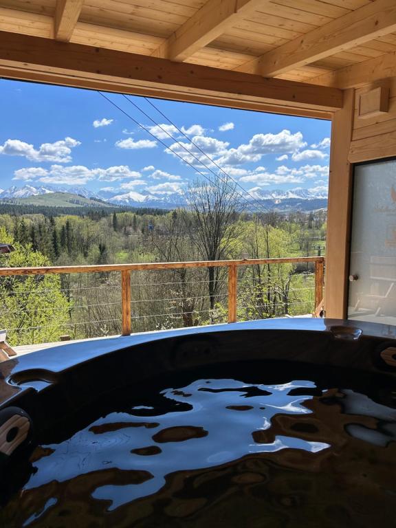 a hot tub in a room with a view of the mountains at u Lucyny w Białce Tatrzańskiej- jacuzzi i sauna w ogrodzie in Białka Tatrzańska