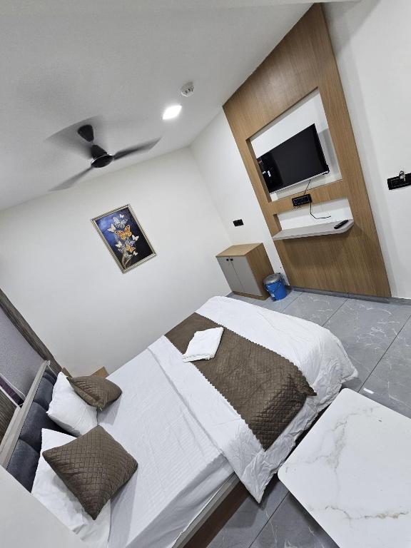 a bedroom with a bed and a flat screen tv at Hotel Royal Heritage in Gandhinagar