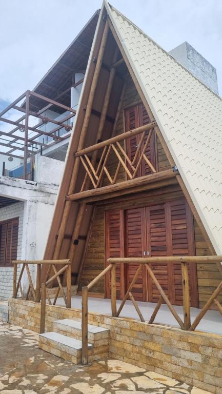 a house under construction with wooden doors and stairs at Cabana Redonda Beach in Icapuí