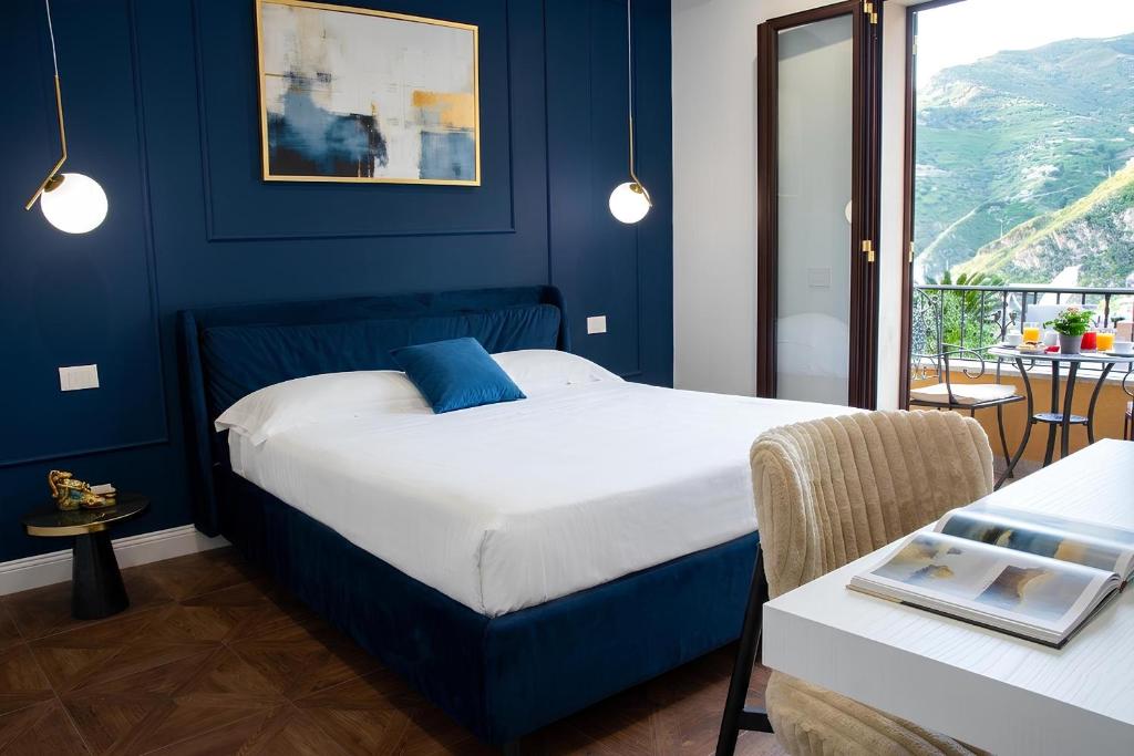 a bedroom with a bed with a blue wall at Gloeden House in Taormina