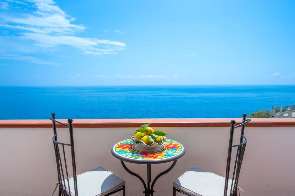 a table with a bowl of fruit on a balcony at Il Giardino Dei Limoni in Praiano