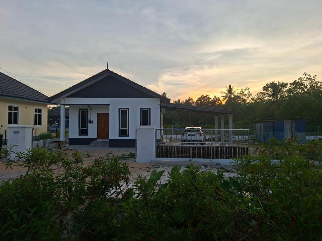 a house with a car parked in front of it at IBY II Homestay in Ketereh