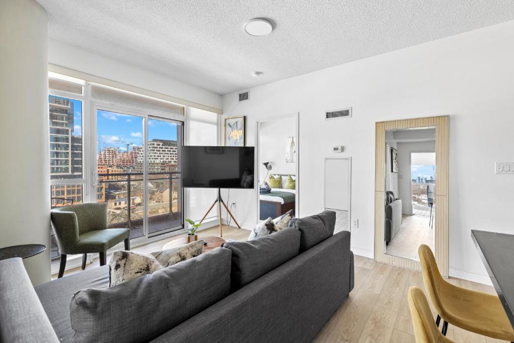 a living room with a couch and a tv at Toronto Harbourview Suites with free parking in Toronto