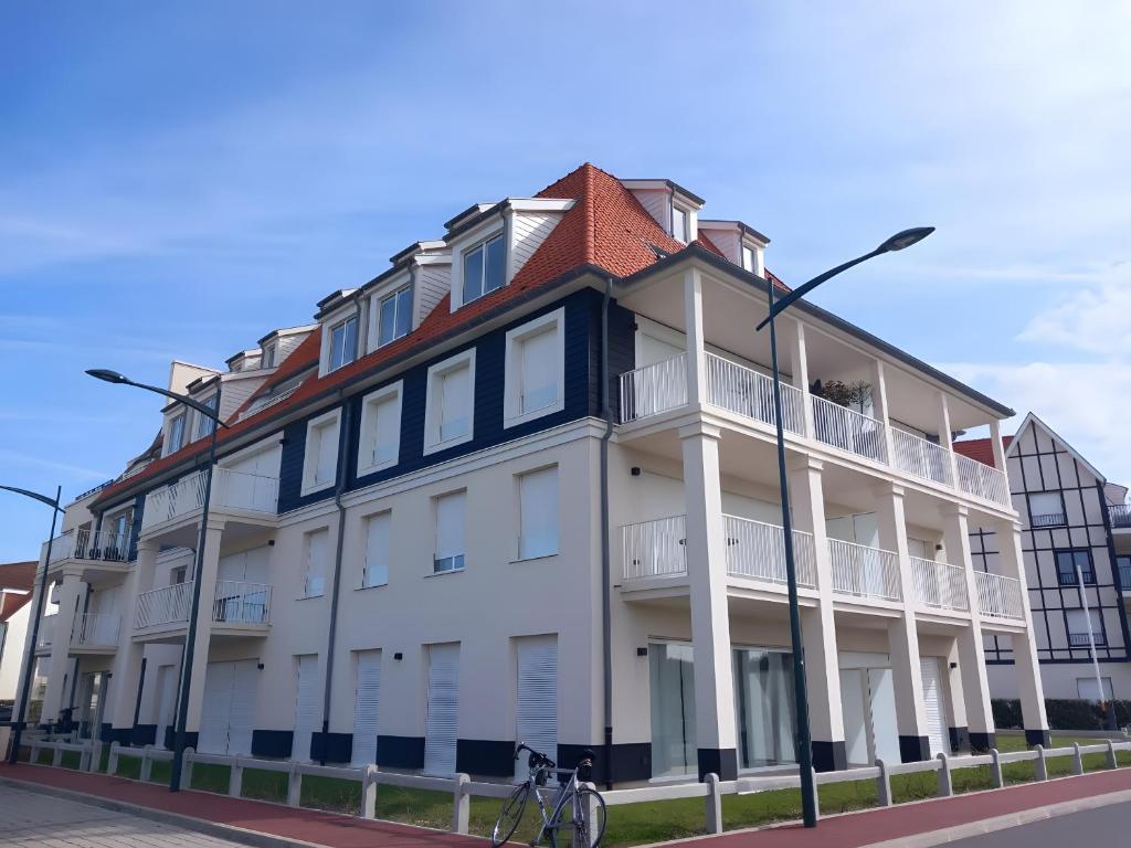 a white and blue building with a bicycle in front of it at Résidence Oscar Wilde entrée A in Neufchâtel-Hardelot