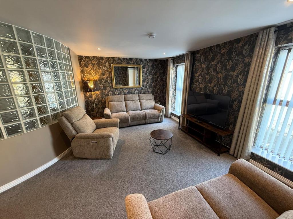 a living room with couches and a couch and a television at Harbour View Holiday Apartment in Donaghadee