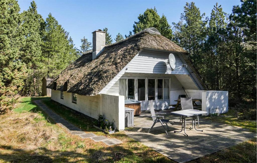 an old house with a thatched roof with a table in front at Holiday Home Narssagsvej in Rømø