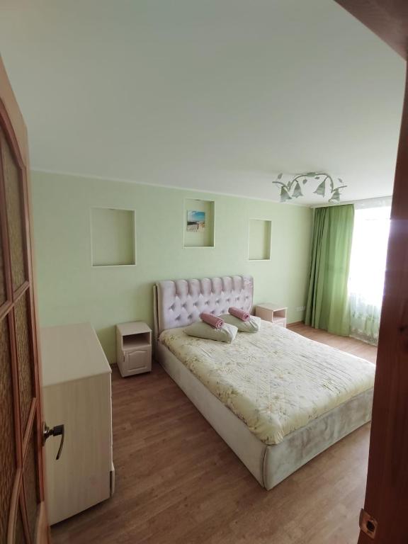 a bedroom with a large bed with a pink headboard at Teatra 34-31 in Daugavpils