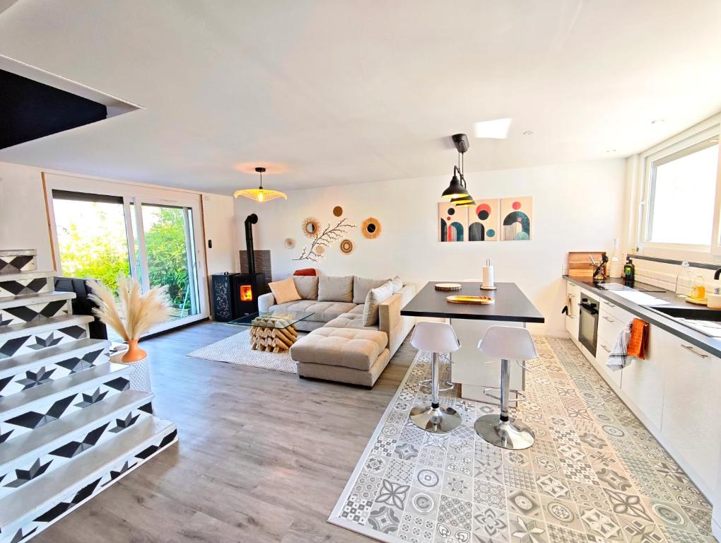 a kitchen and living room with a couch and a table at Maison chaleureuse - Proche du lac in Tresserves
