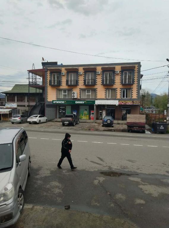 a person crossing the street in front of a building at Hotel Pagio in Chaisubani