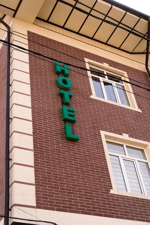 a hotel sign on the side of a brick building at Tourist inn Tashkent in Toshkent-Passajir Bekati