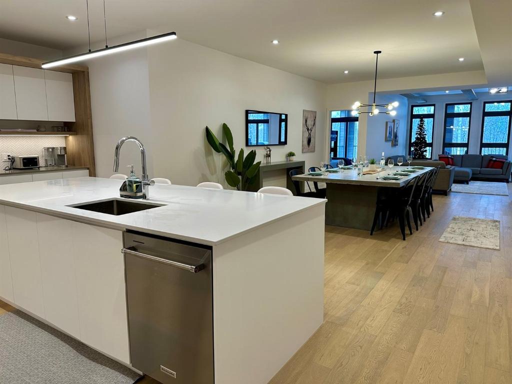 a kitchen and living room with a sink and a table at Superb 3brm - Spacious, GamesSpaSaunaGym in Mont-Tremblant