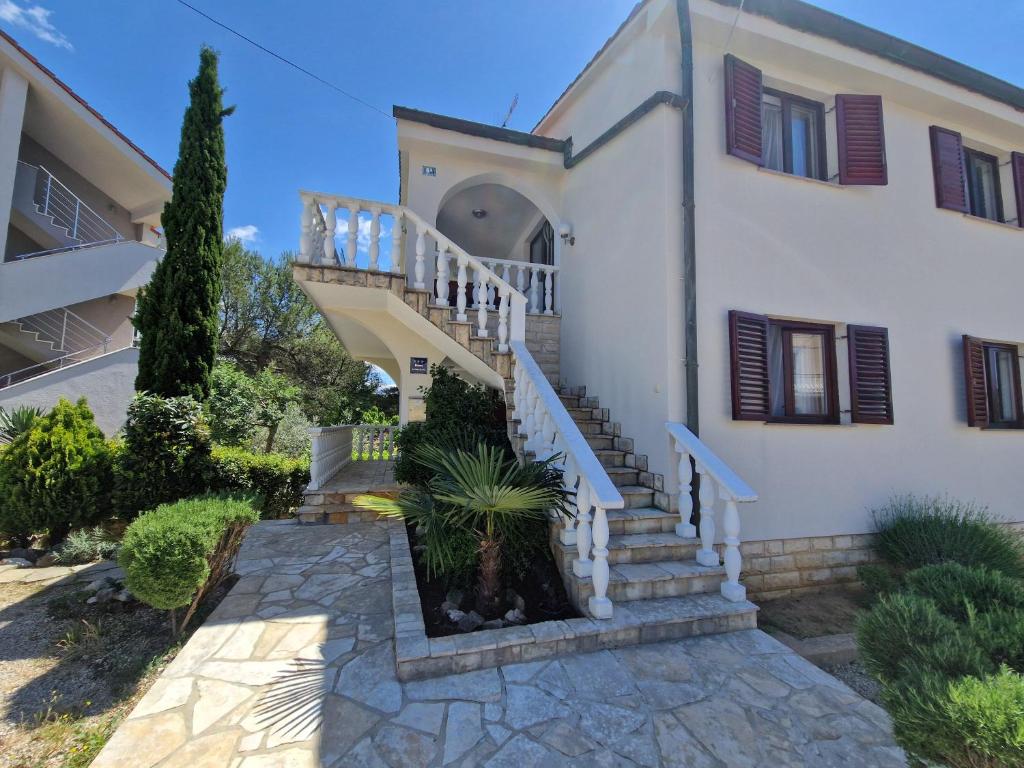 a house with a staircase in front of it at Apartment Ruzmarin in Šilo
