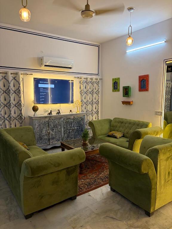 a living room with green couches and a window at C44thelocalhistory in Jaipur