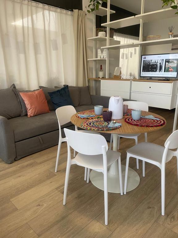 a living room with a table and chairs and a couch at pinetadamare in Porto SantʼElpidio