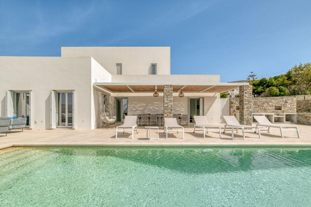 a villa with a swimming pool and a house at Villa Ariadni Paros in Isterni