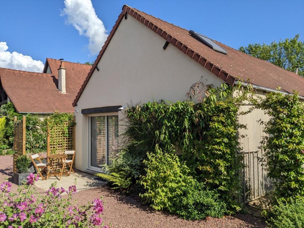 a white house with a fence and some bushes at Gîte de la Pinsonnerie in Fondettes