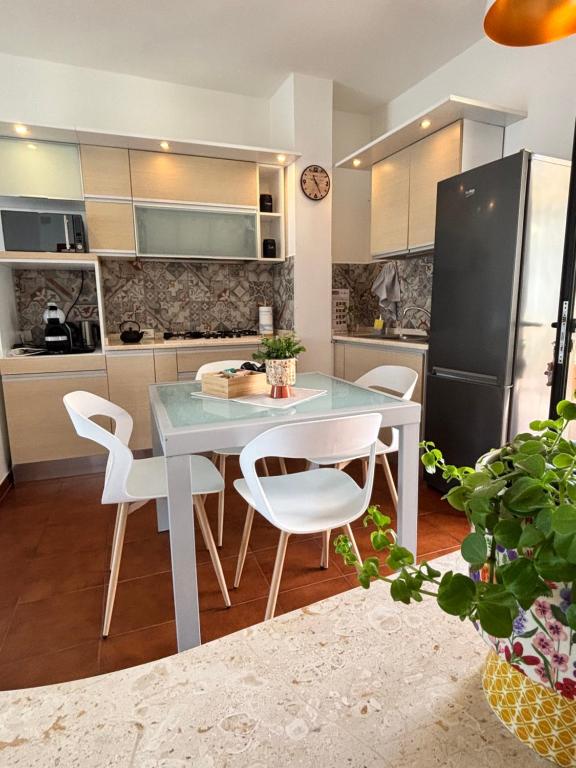 kuchnia ze stołem, krzesłami i lodówką w obiekcie Dimidium Apartment w mieście Guspini