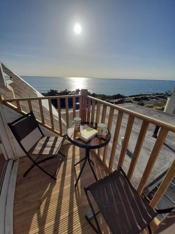 a balcony with a table and chairs and the ocean at Shellsborough Penthouse in Woolacombe