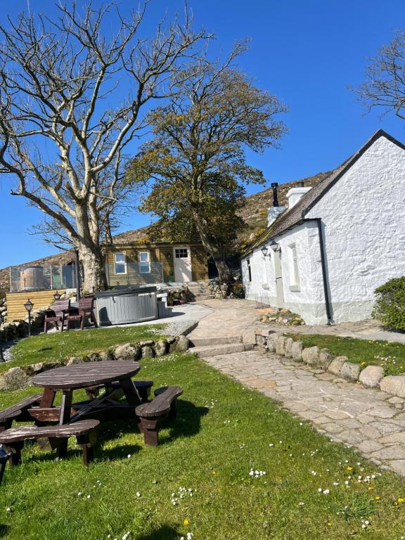 a picnic table in the grass next to a building at Carrick Cottage - Mourne Mountains in Annalong