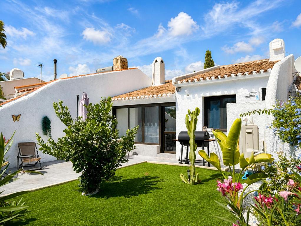 a white house with a yard with green grass at Casa Etxetxoa - Calpe in Ifach