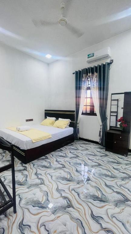 a bedroom with a bed and a carpet at MOMS Villa in Arugam Bay