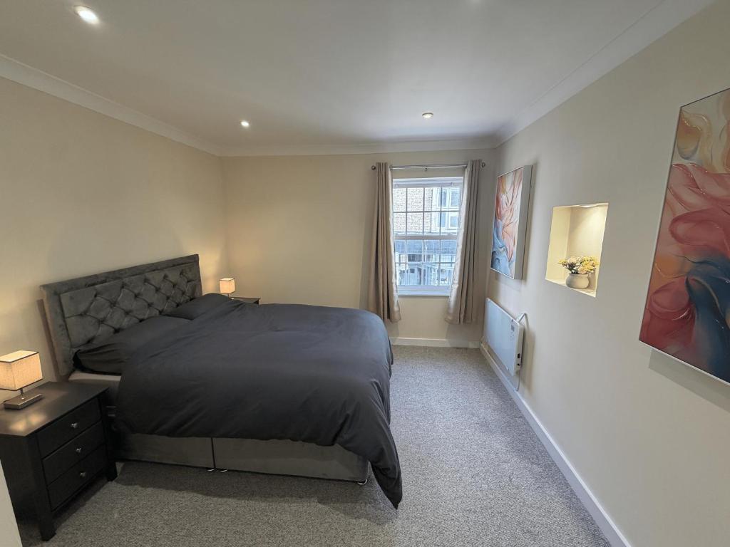 a bedroom with a large bed and a window at Ely Stays City Center 2 Bedroom Flat in Ely