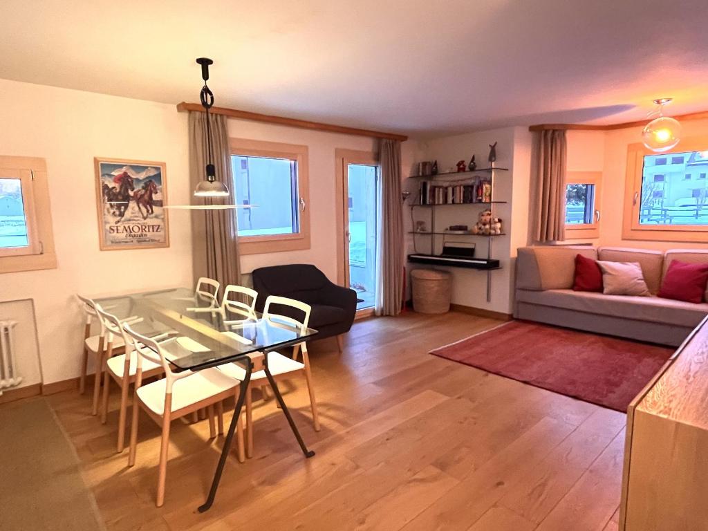 a living room with a glass table and a couch at Chesa Silvretta - Celerina in Celerina