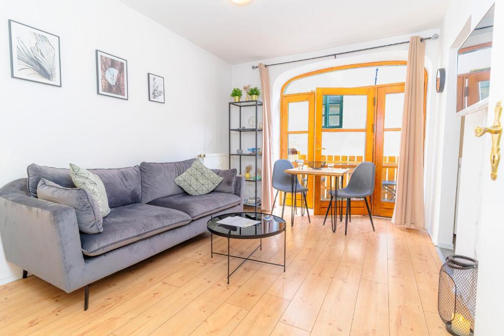 a living room with a couch and a table at fewo1846 - Smutjes Koje - für eine entspannte Auszeit mit Balkon im Stadtzentrum in Flensburg