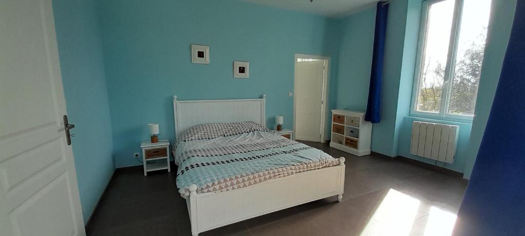 a bedroom with blue walls and a bed in it at Le Gite des Sources in Lormes