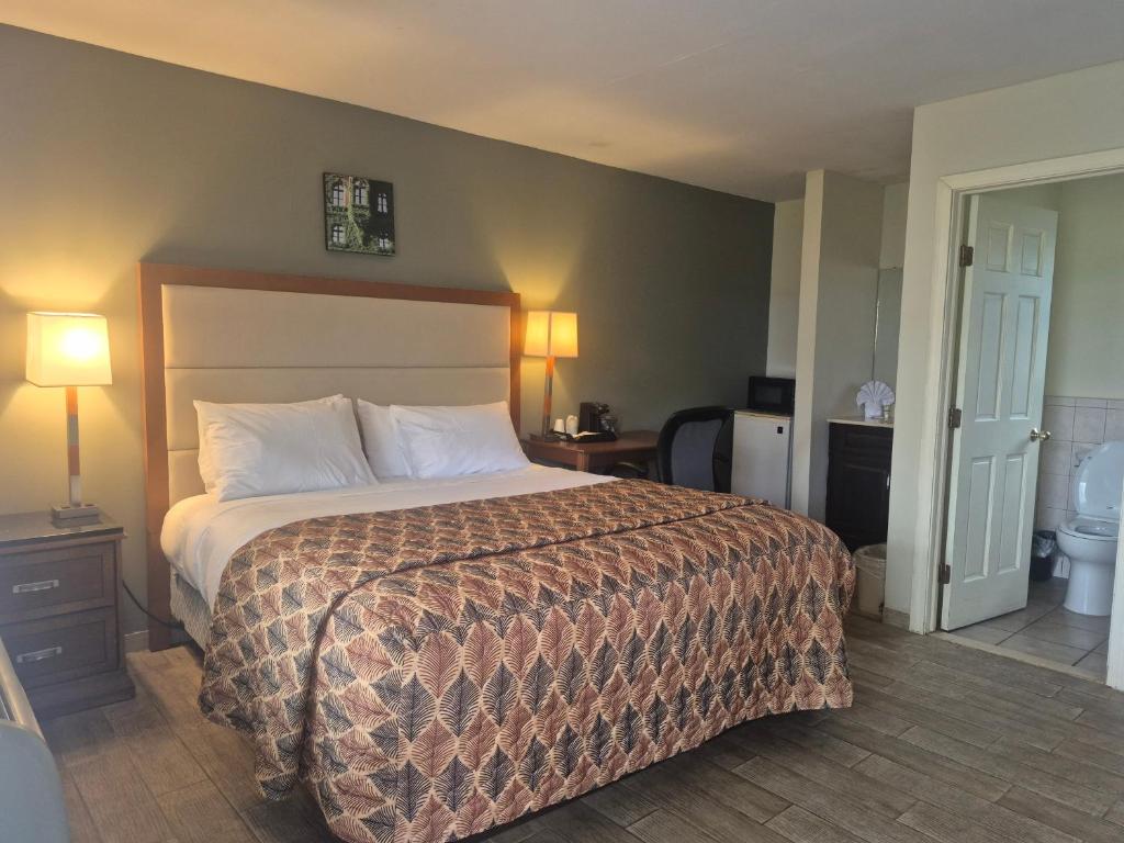 a hotel room with a bed and a bathroom at Maple leaf motel in New Milford