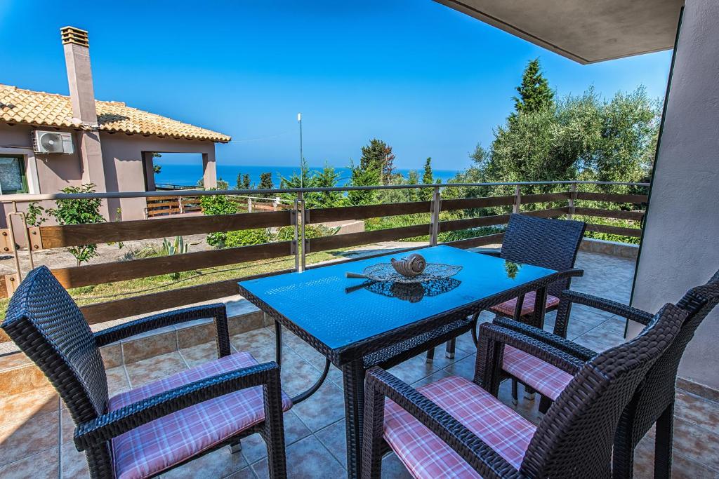 a table and chairs on a patio with a view of the ocean at Eltheo Villas in Agios Nikitas