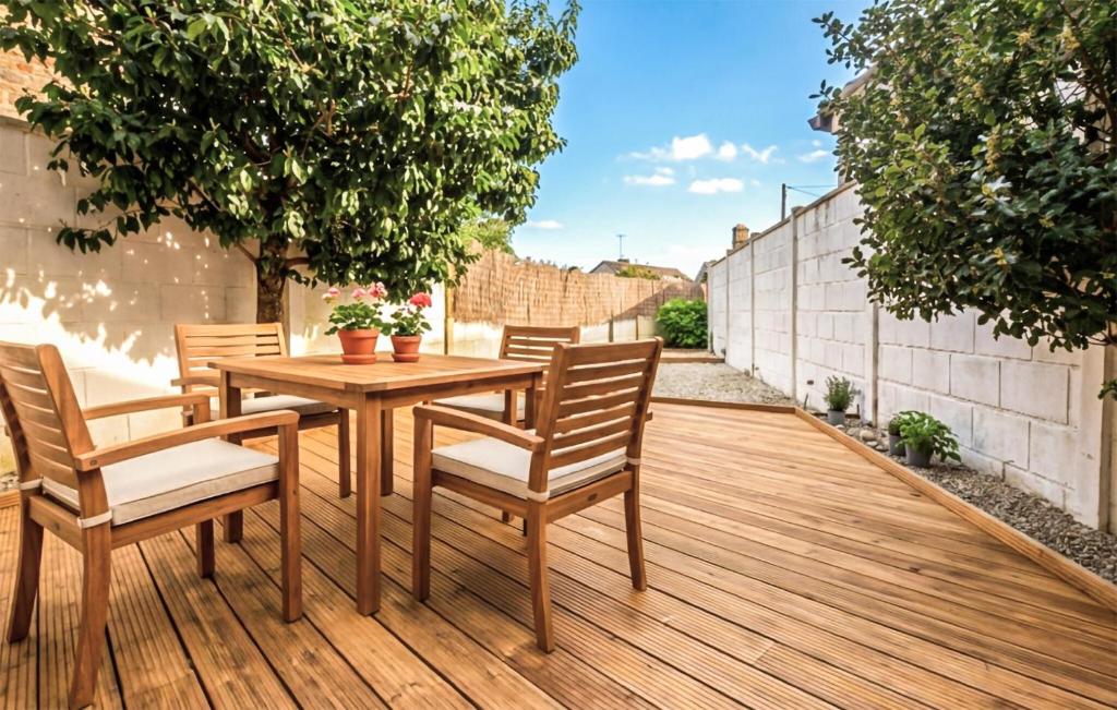 a wooden table and chairs on a wooden deck at Agréable Jardin Et Terrasse in Sourdeval