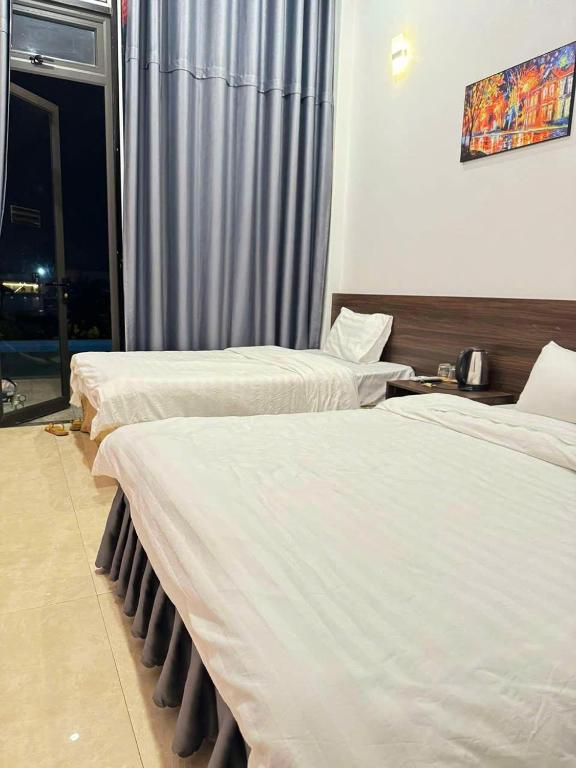 a hotel room with two beds and a window at AIEM Moc Chau in Mộc Châu