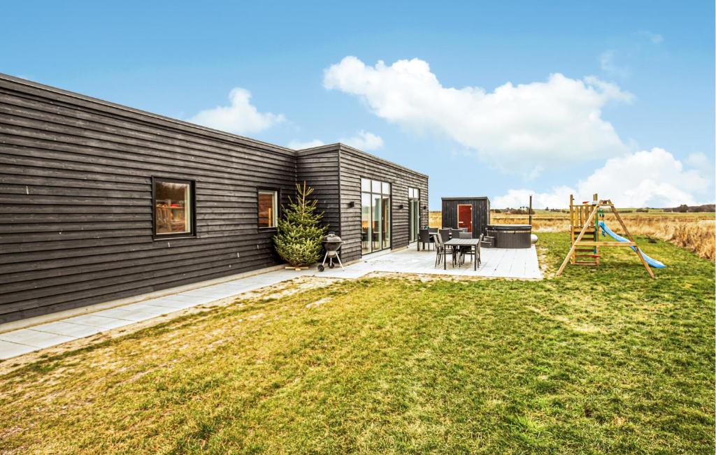 a black house with a playground in the yard at Gorgeous Home In Grenaa With Sauna in Grenå