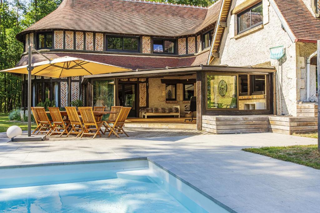 a house with a swimming pool in front of a house at Lodge de Loire - B & B proche Chambord in Saint Laurent Nouan