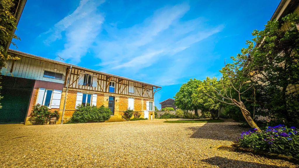 a house with a gravel driveway in front of it at L'Aube du Lac in Drosnay