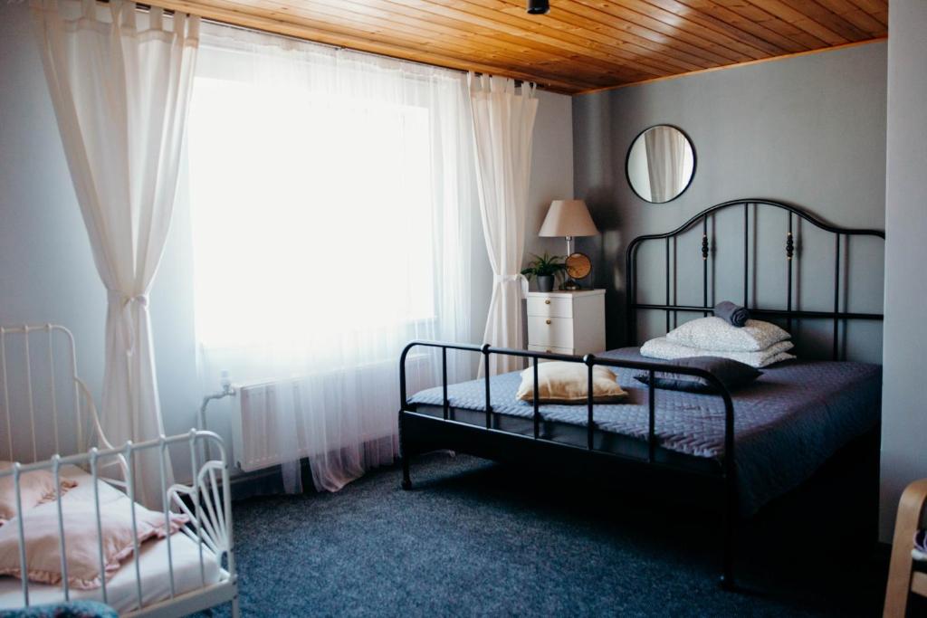 a bedroom with two beds and a window at Avotu rezidence Apē in Ape