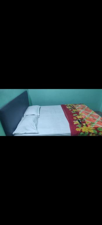 a bed with a blanket and pillows on it at HOTEL SEA ROCk in Belagula
