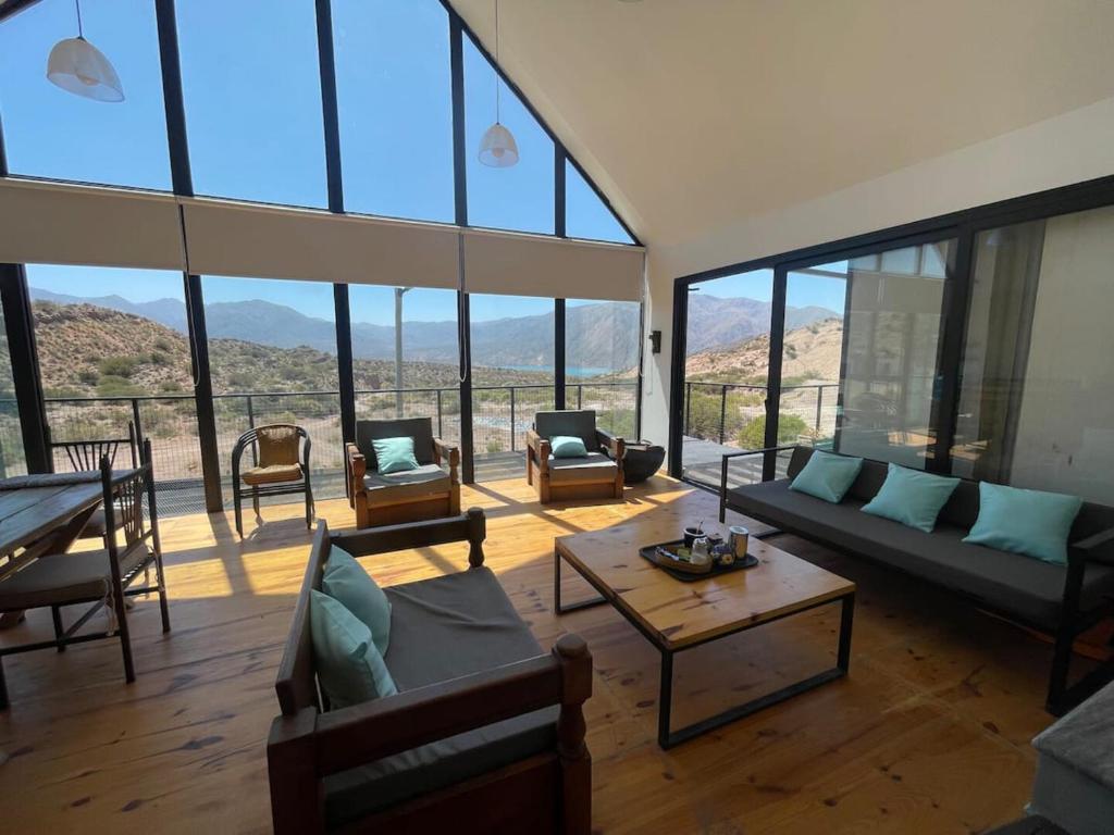 a living room with couches and a table and windows at Cabaña San Charbel in Potrerillos