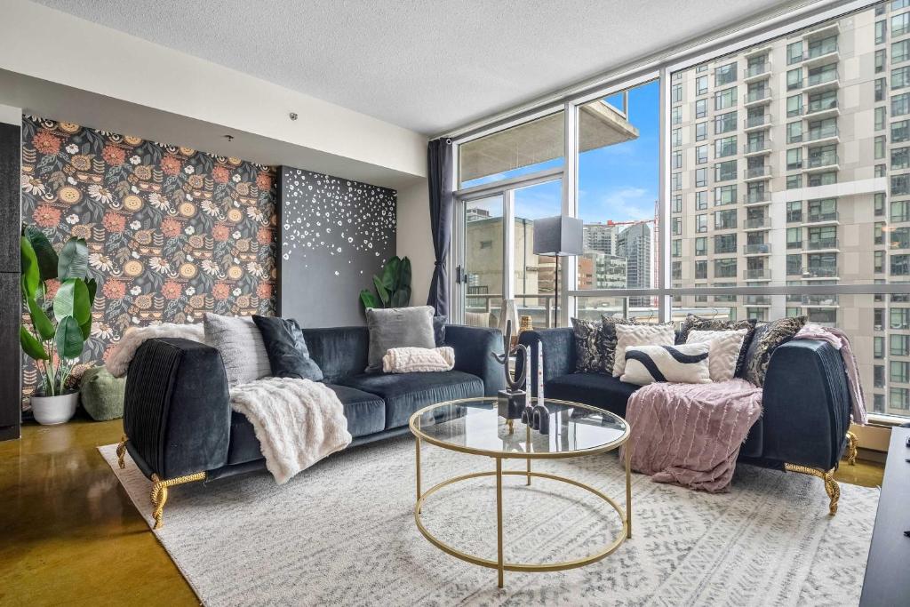 a living room with a blue couch and a table at Jungle Book Luxe Suite Downtown BMO in Calgary