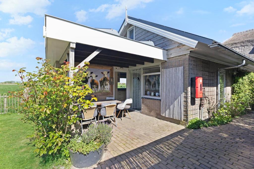 a house with a white awning on a patio at De Zilverreiger op camping Oudesluis in Oudesluis