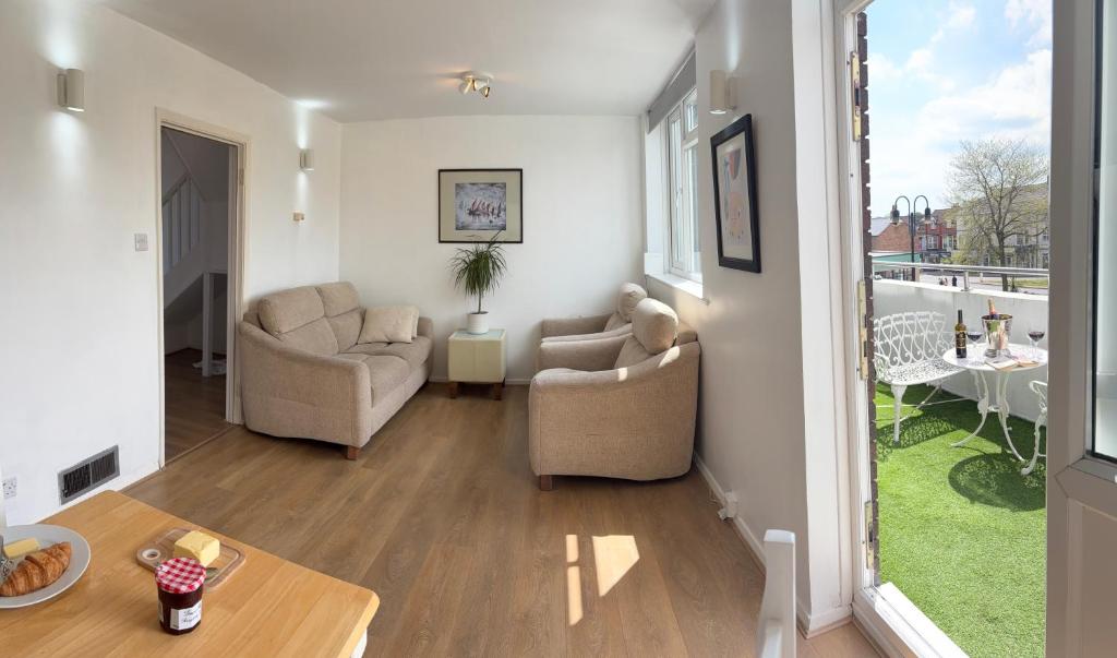 a living room with two chairs and a table at Two Floor Flat in Town Center in Kenilworth