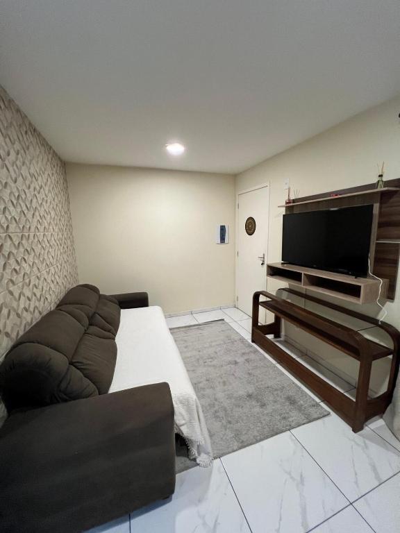 a living room with a couch and a flat screen tv at Apartamento in Campo Largo