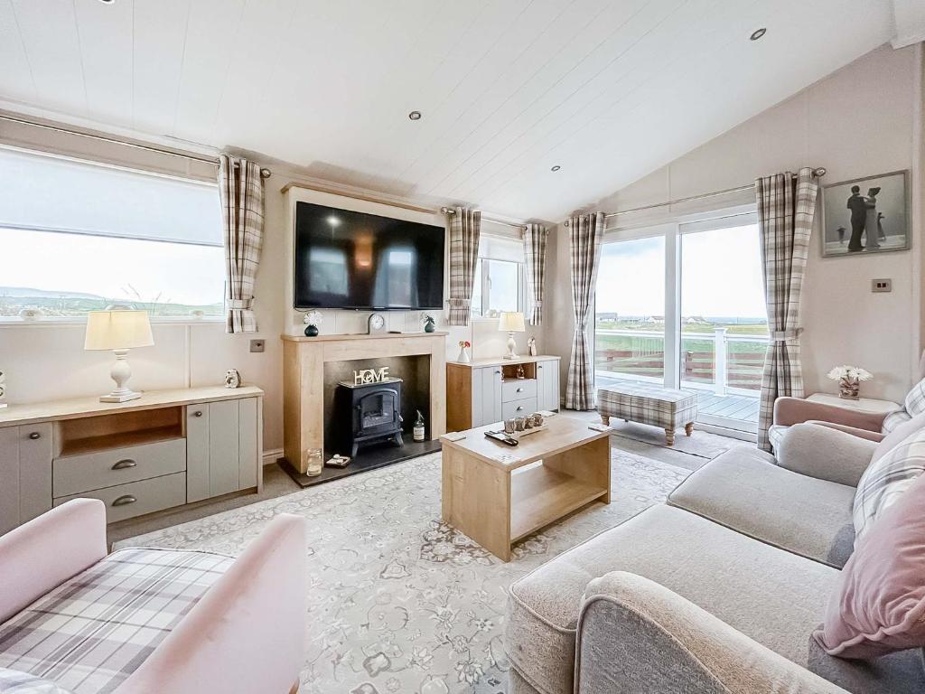 a living room with a couch and a tv at Turnberry Lodge in Girvan