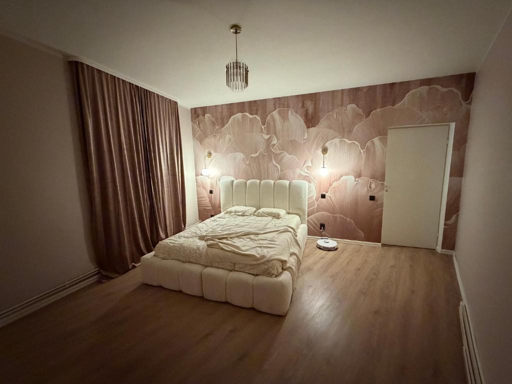 a bedroom with a white bed and a painting on the wall at Luxe Lumine Apartment #2 in Kohtla-Järve